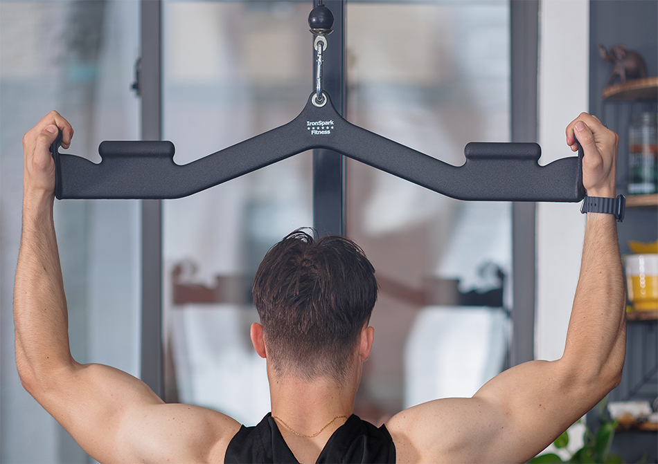 Person in gym setting holding a neutral grip on a lat pulldown bar