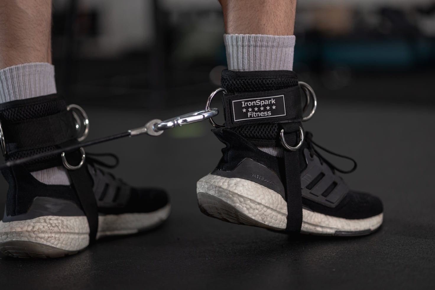 Close-up of an athlete's lower leg wearing IronSpark Fitness ankle strap attached to a cable machine 